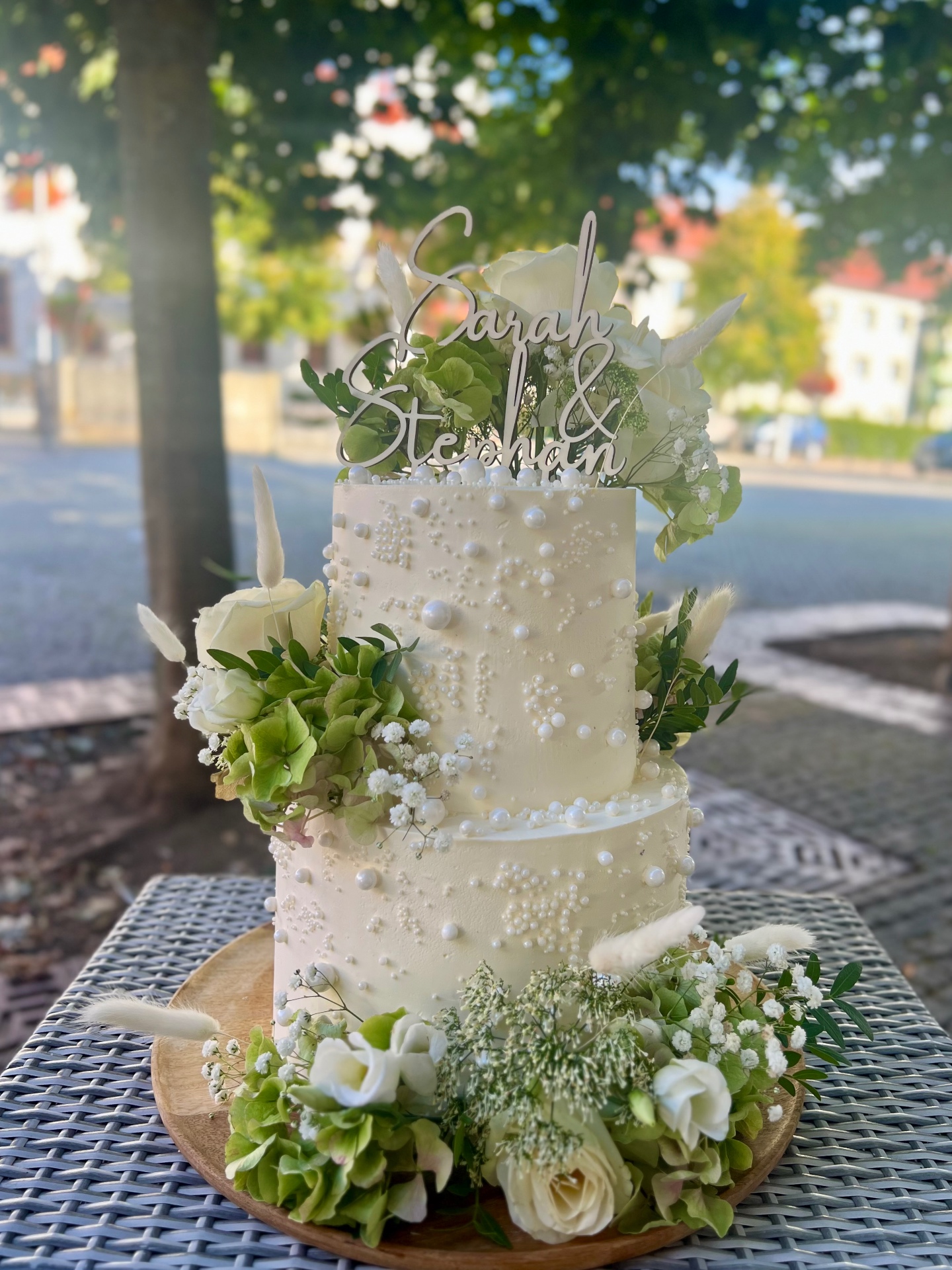 Sarah & Stephan — Zweistöckig in Cremeweiß mit Zuckerperlen, weißen Rosen und grüner Hortensie.. Hochzeitstorte aus Lauras Tortenmanufaktur, Meitzendorf bei Magdeburg.