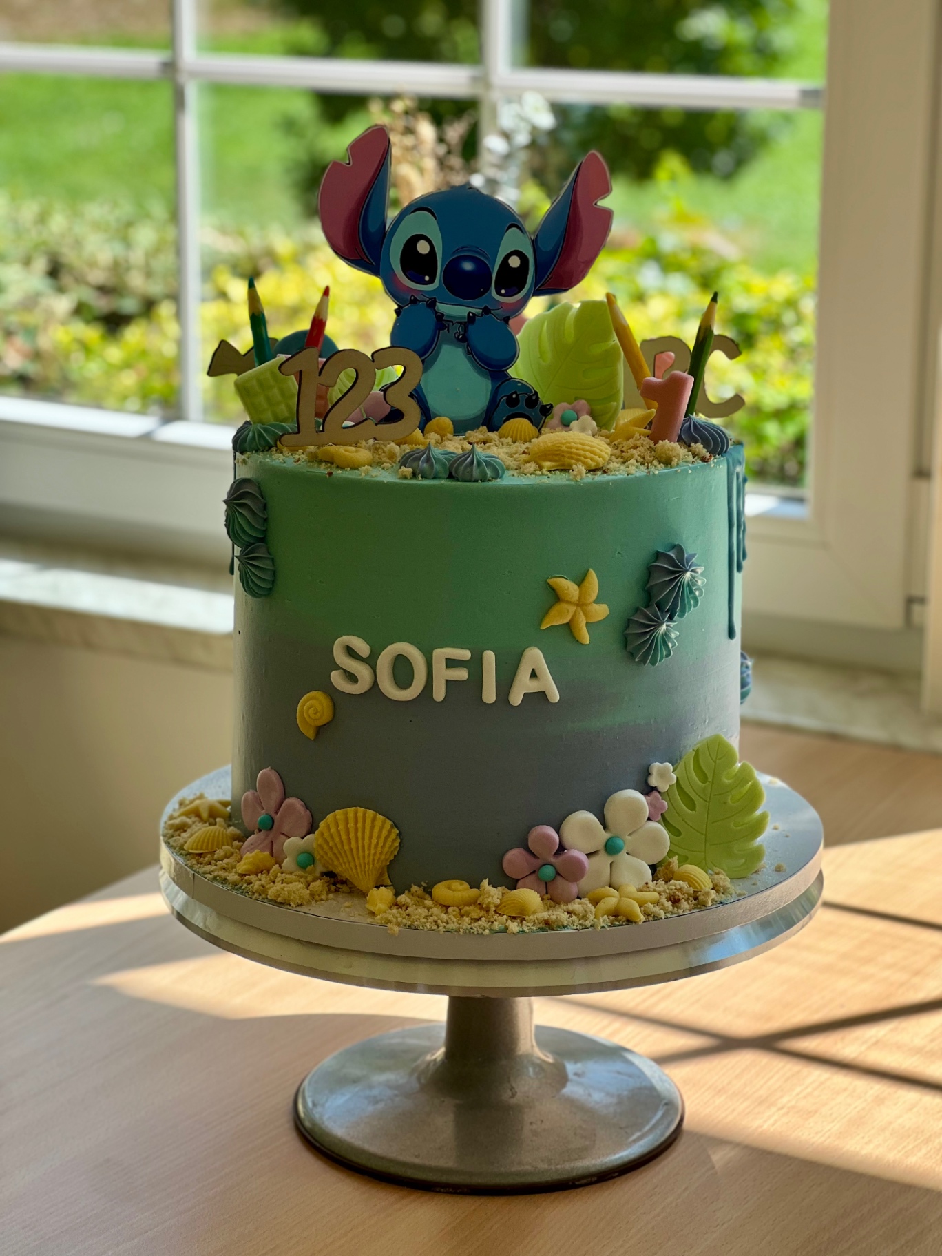 Sofia — Stitch — Türkis mit Stitch-Topper, Palmenblättern, Muscheln und Sandstrand.. Motivtorte aus Lauras Tortenmanufaktur, Meitzendorf bei Magdeburg.