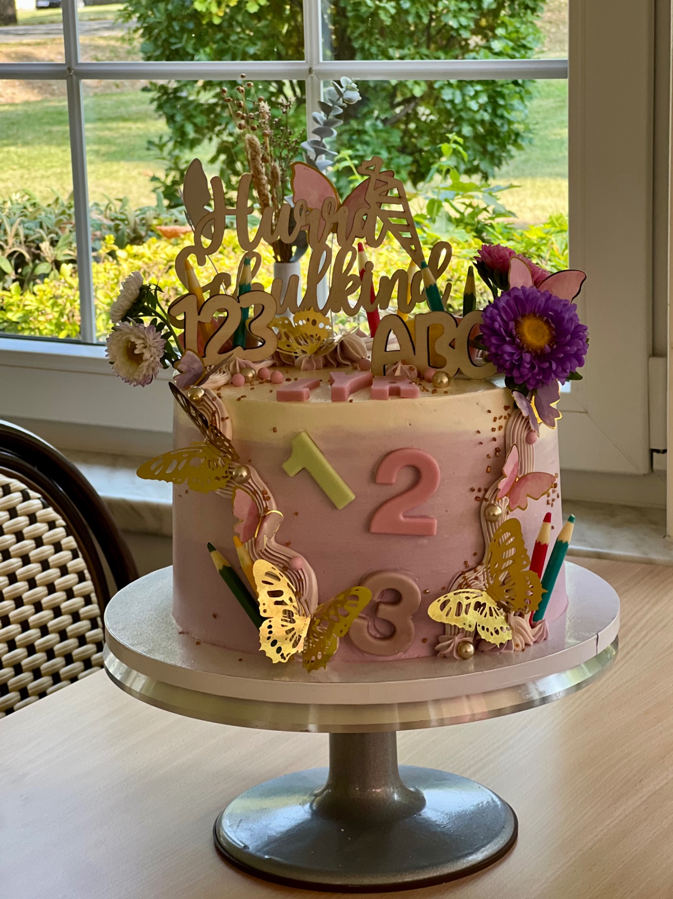 Hurra Schulkind — 1 · 2 · 3 — Rosa mit Zahlen, goldenen Schmetterlingen und Herbstblüten.. Motivtorte aus Lauras Tortenmanufaktur, Meitzendorf bei Magdeburg.