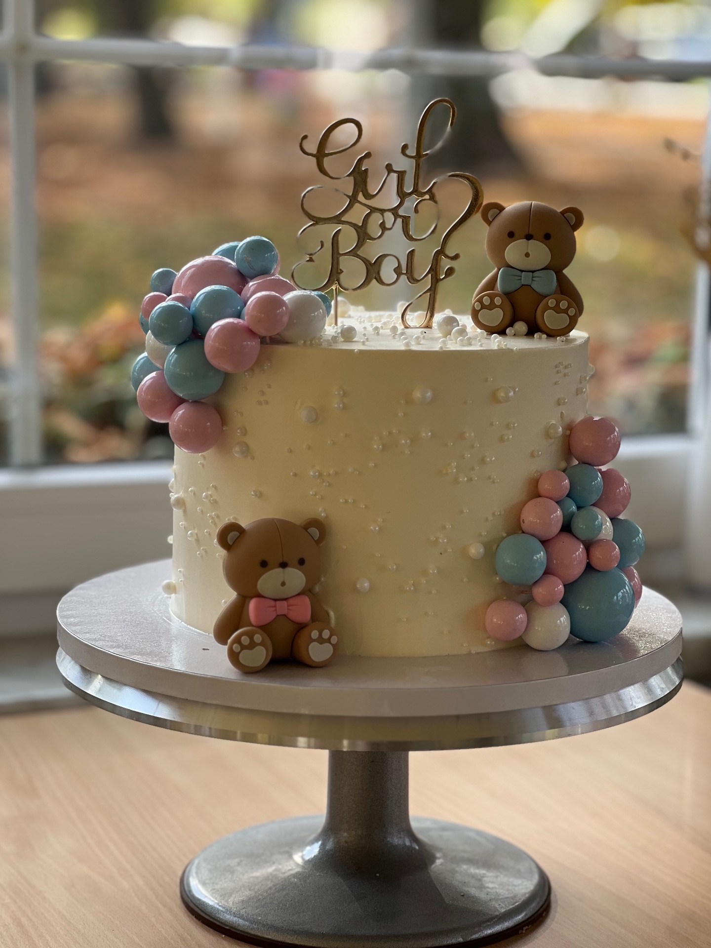 Girl or Boy? — Cremeweiß mit rosa und blauen Choco-Balls und Teddybär-Toppern.. Motivtorte aus Lauras Tortenmanufaktur, Meitzendorf bei Magdeburg.